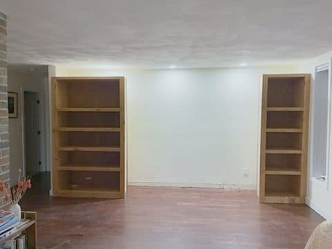 Installed empty bookcases flanking wall