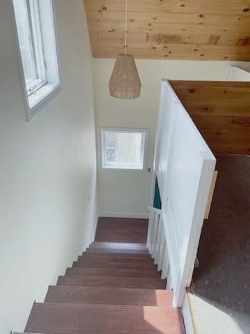 Finished stair looking down, white balustrade wall