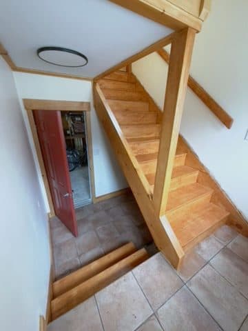 Finished stair, honey-stained treads + newel + handrail