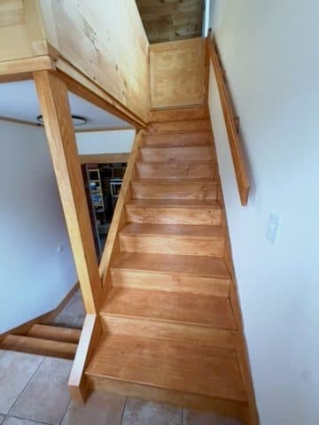 Finished stair, honey stain, newel + handrail