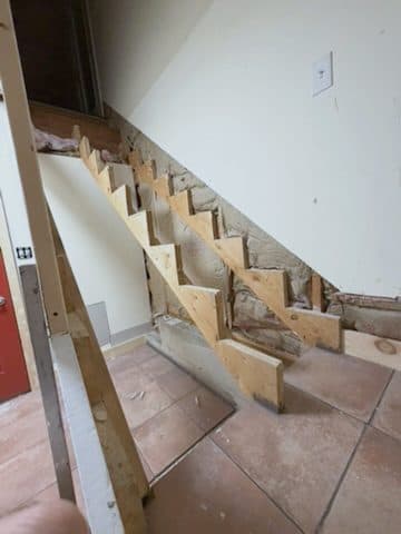 Sawtooth stringers fixed to wall