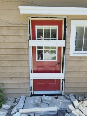 Red exterior door braced in rough opening